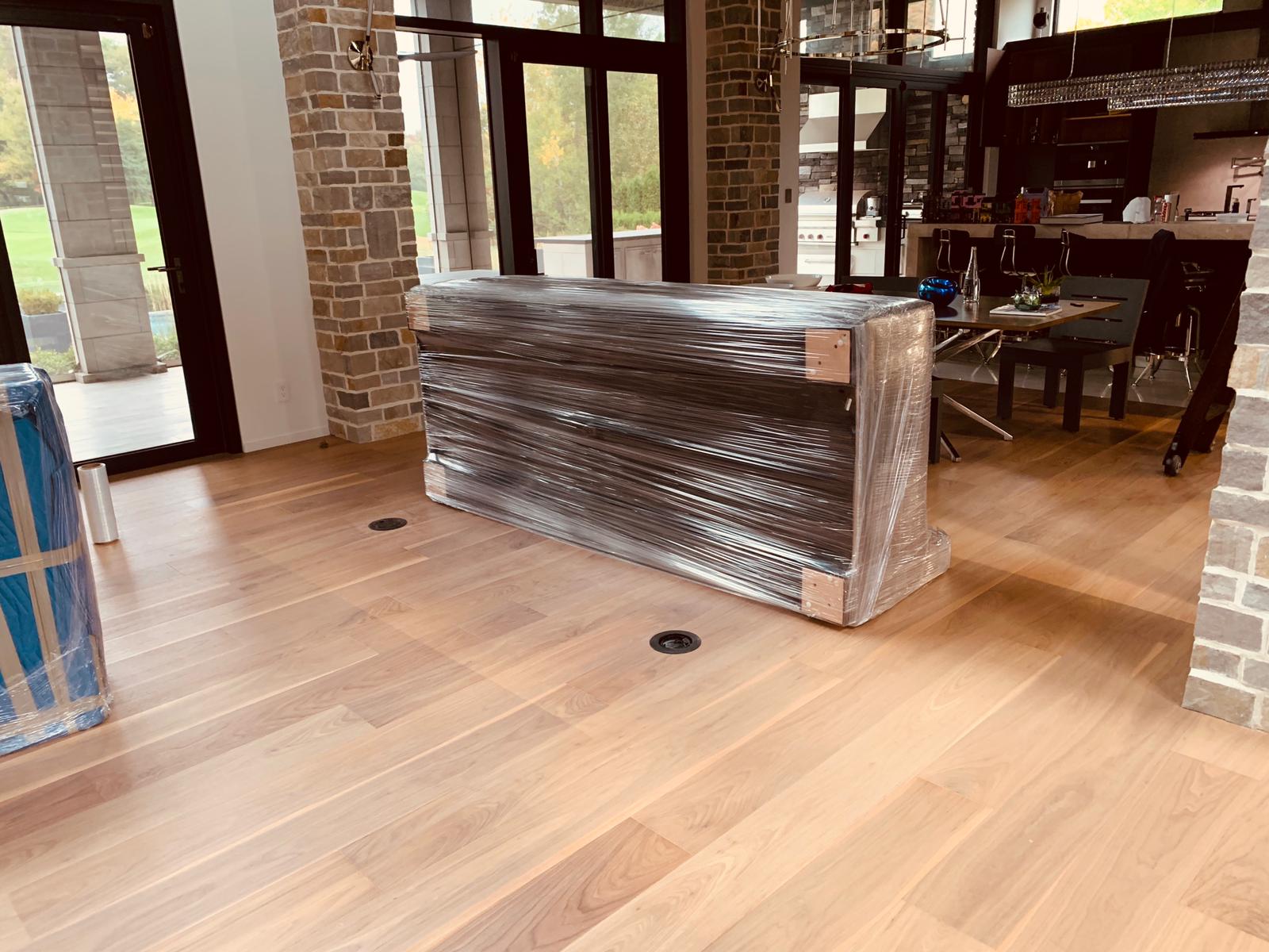 alt="Living room with all sofas wrapped in blankets for protection during a move"