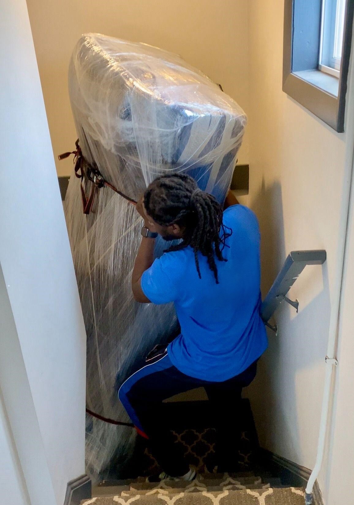 alt="Two men bringing a big sofa down the stairs"